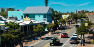 Sunny street scene in Siesta Key Village, Florida, with colorful buildings and walkable sidewalks, setting the scene for this where to eat on Siesta Key dining guide.