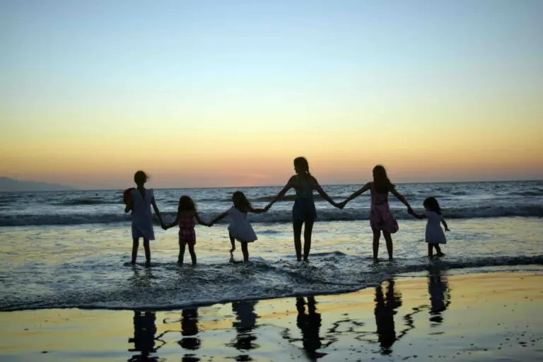 Family holding hands at sunset on a Siesta Key beach, Florida, illustrating spring break crowds and the trip-planning vibe in peak season