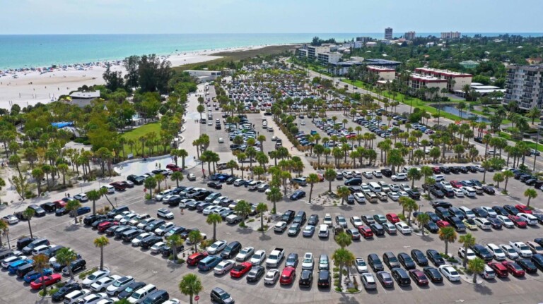 Aerial view of the Siesta Key Beach parking lot in Sarasota, Florida, showing peak arrival timing and Siesta Key beach parking demand