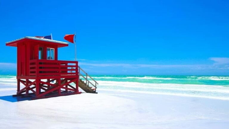 Red lifeguard stand on Siesta Beach, Siesta Key, Florida with turquoise Gulf water for our Siesta Key water clarity planning guide